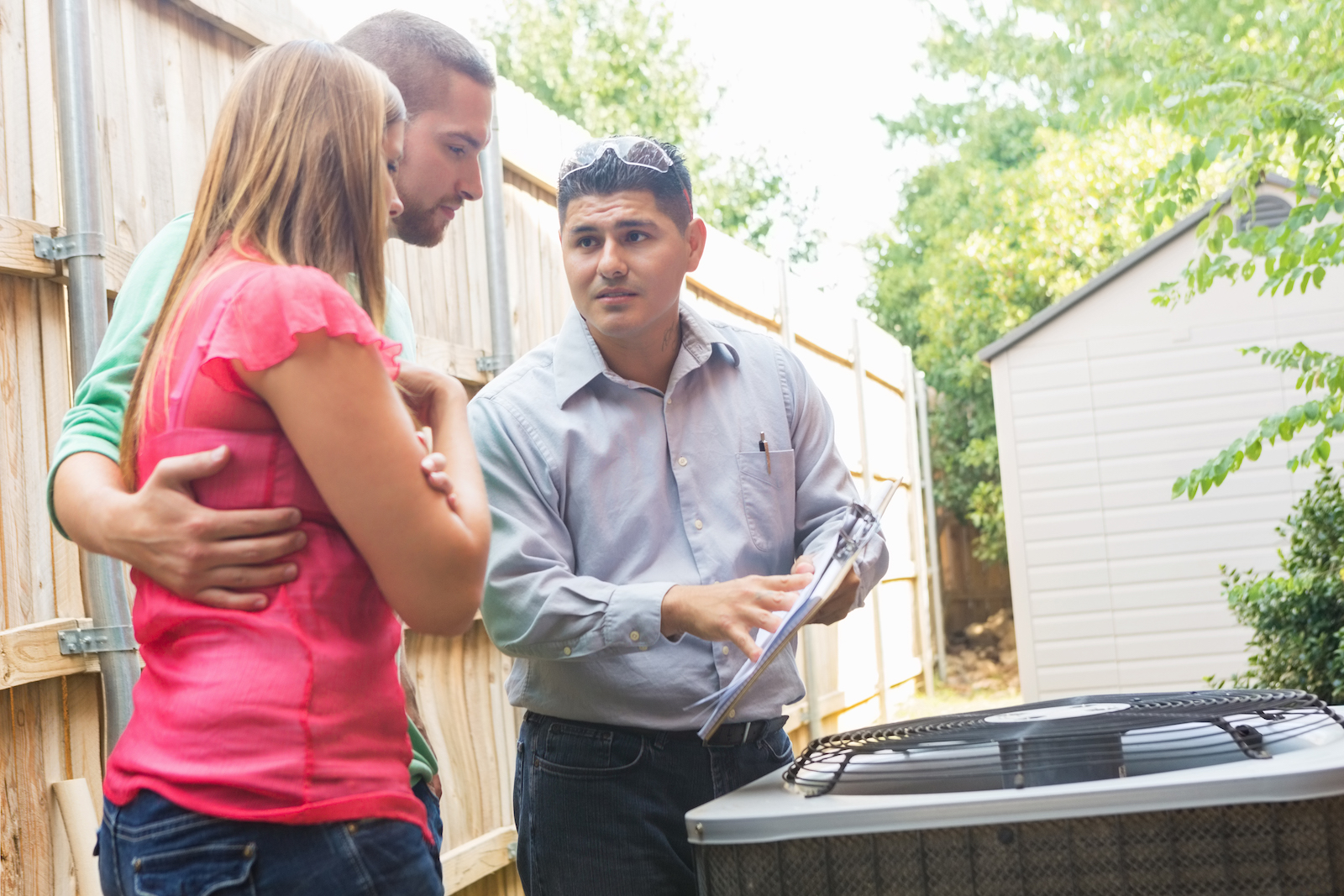 Air Conditioner repairman explaining cost of repairs to Raleigh homeowners